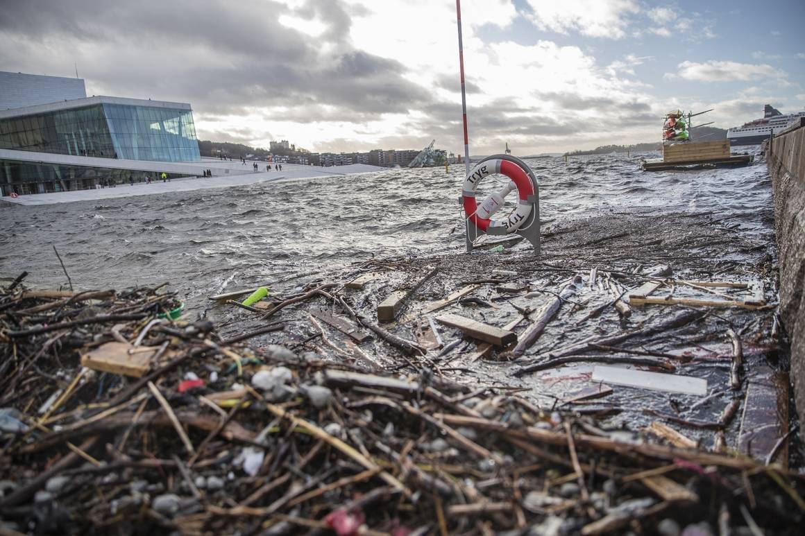 Bildet viser søppel som har drevet mot land ved operaen i Oslo. Vannstanden er så høy at stativet til en redningsbøye foran operaen ser ut som at det er plasserte ute i havet. Foto: Stian Lysberg Solum/NTB scanpix